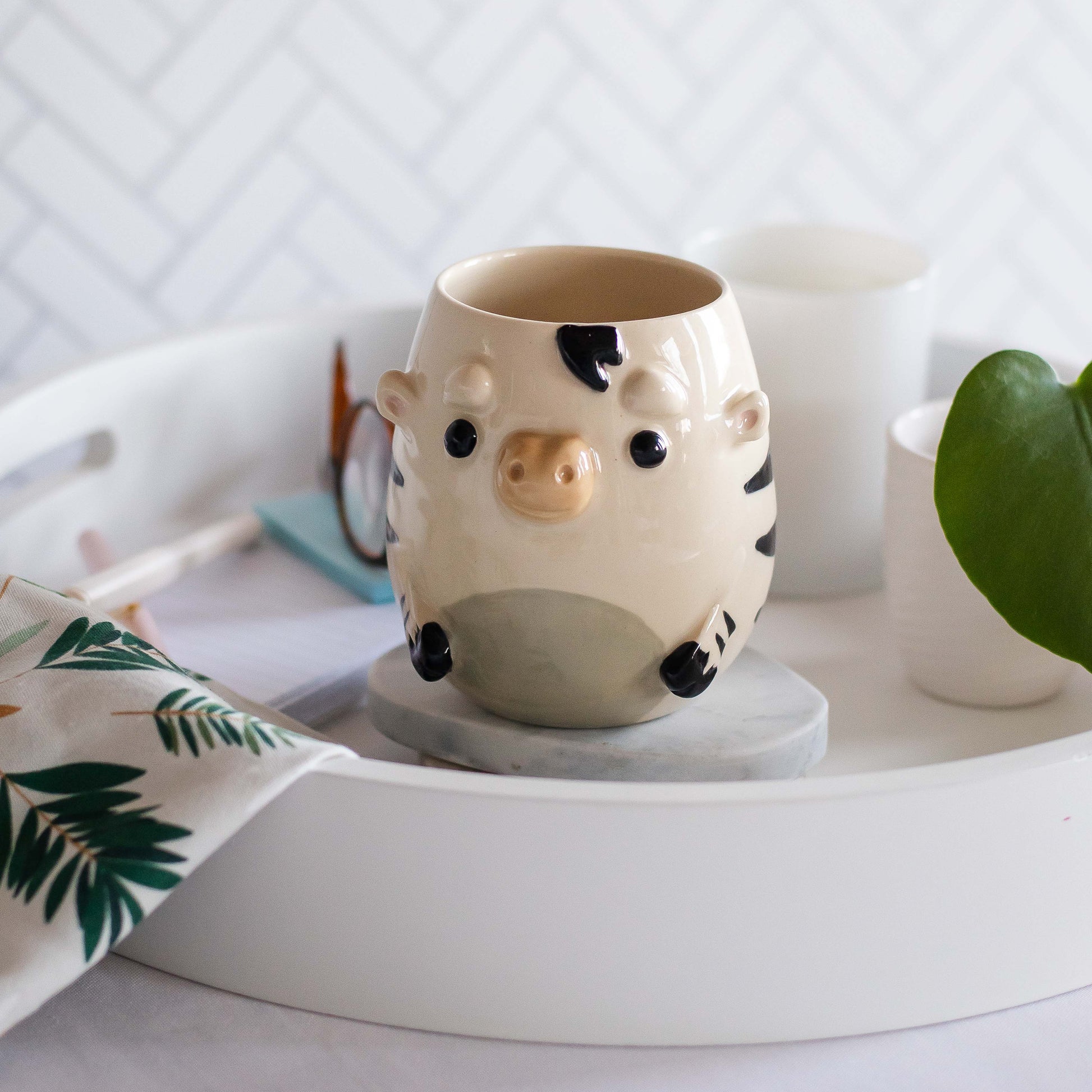 Ceramic zebra mug shaped on a white tray with a light background