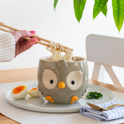 Sculpted owl shaped bowl with noodles and a boiled egg on a table