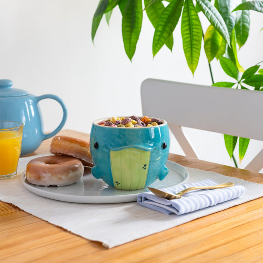 Whale shaped ceramic bowl with breakfast items on a wooden table