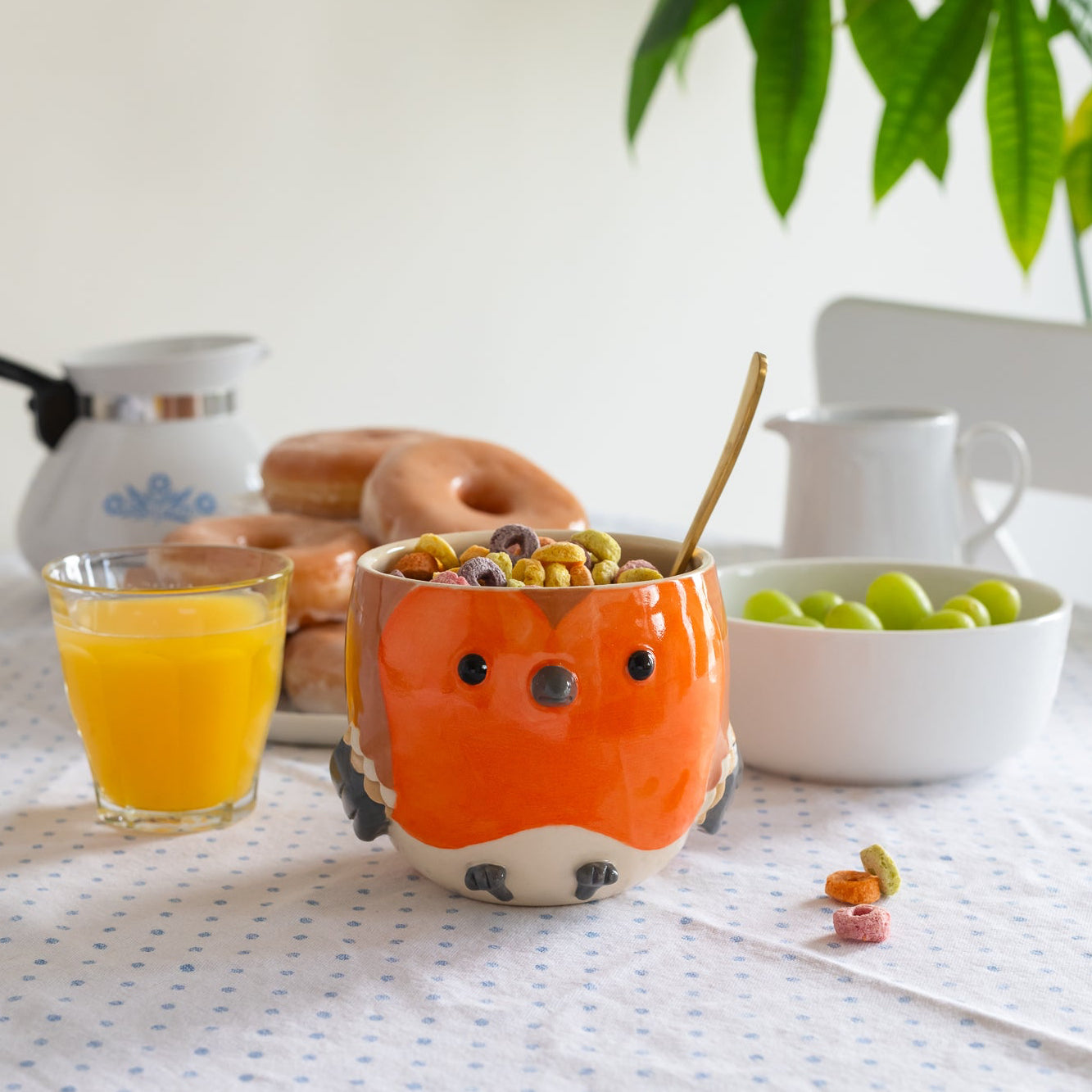 Sculpted robin bowl on a table with breakfast items